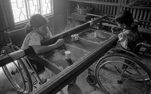 Two physically challenged girls engaged in embroidery on clothes at The Centre for the Rehabilitation of the Paralysed, CRP at Savar, Dhaka, Bangladesh, 2005
